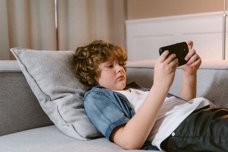 boy playing video games on cell phone